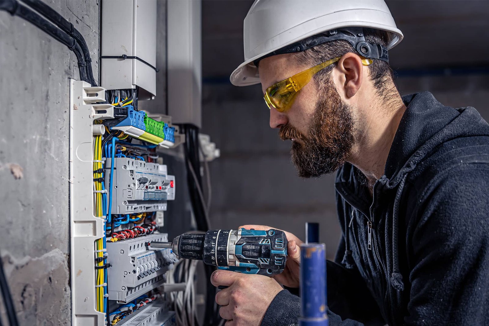 a-male-electrician-works-in-a-switchboard-with-an-9R6YVGW.jpg